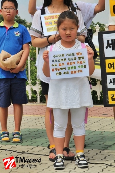 엄마와 함께 참여한 어린이가 특별법으로 안전한 사회를 요구하는 피켓을 들고 있다.